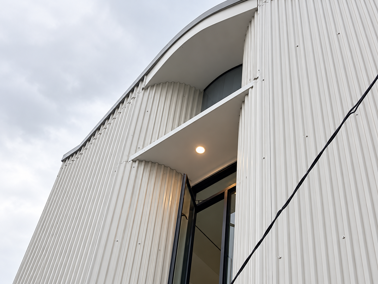 Curved Minimalist Facade Under Overcast Skies.png