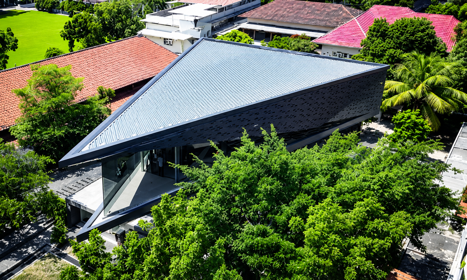 Modern Triangular Building Amid Greenery.png